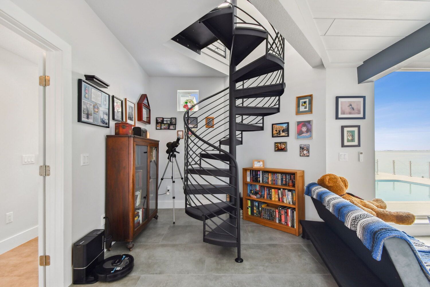 Cozy reading nook with black spiral staircase and lake views — Waterfront home renovation, Bradenton, FL