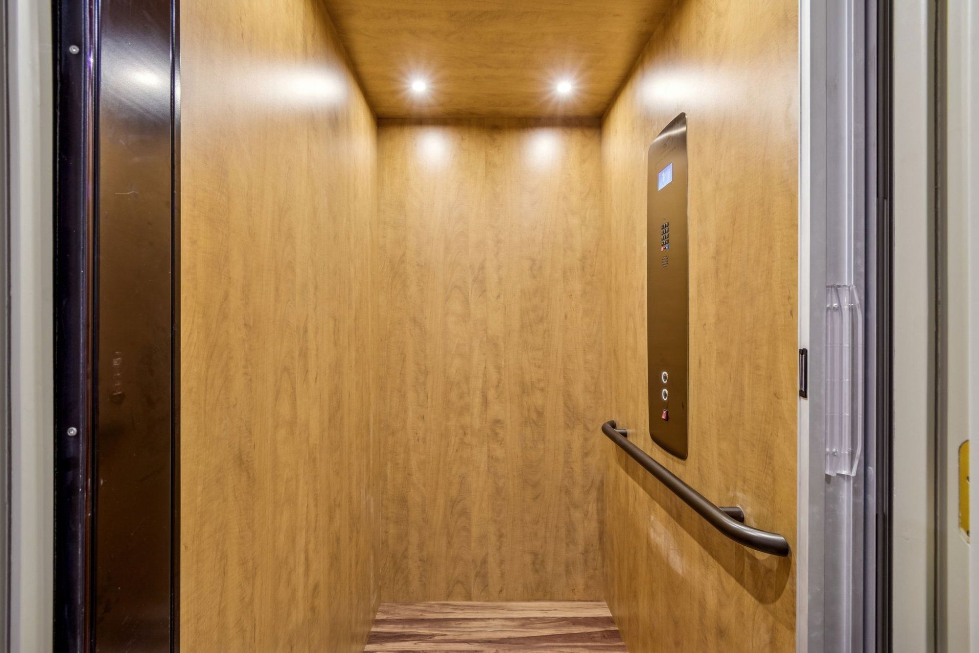 Interior private elevator wood paneled cab recessed lighting handrail — Custom home addition, Longboat Key