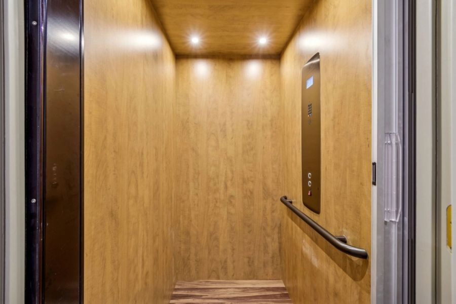 Interior private elevator wood paneled cab recessed lighting handrail — Custom home addition, Longboat Key