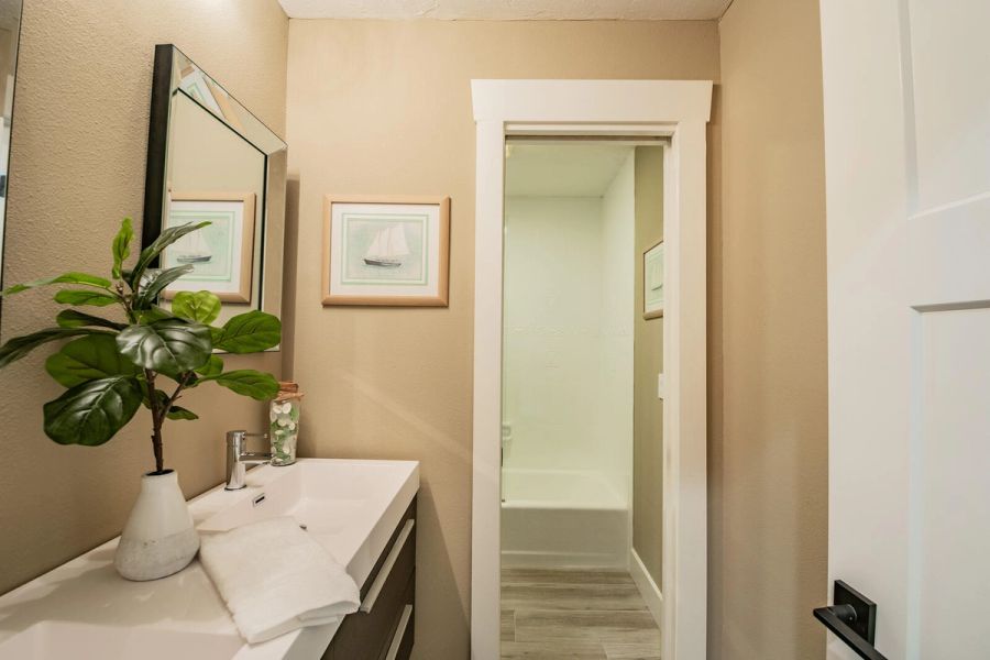 Guest bathroom with vanity and shower hallway — Custom home addition, pool, and renovation, Bradenton