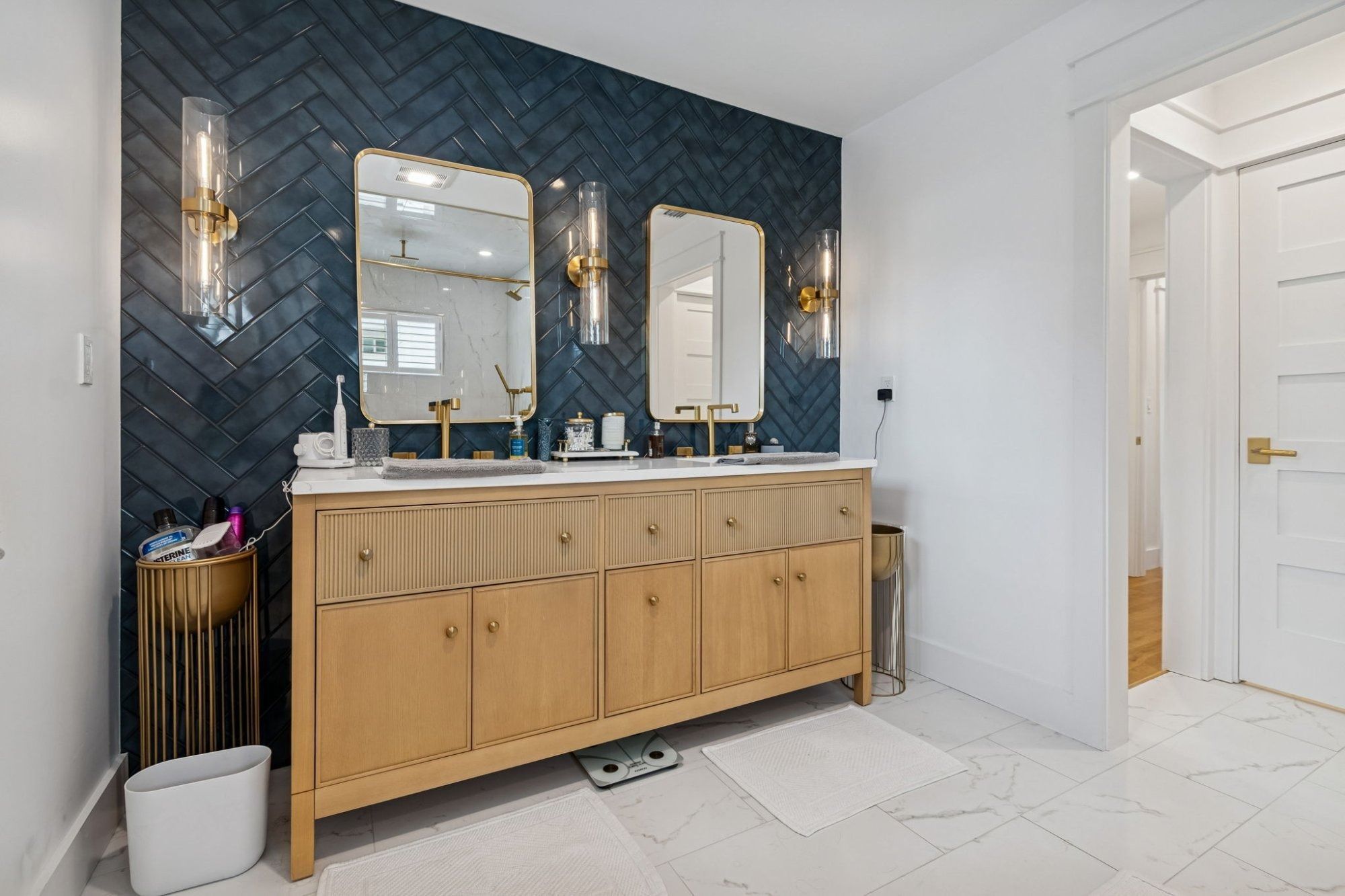 Interior primary bath double vanity navy herringbone tile gold mirrors sconces — New home construction, Longboat Key