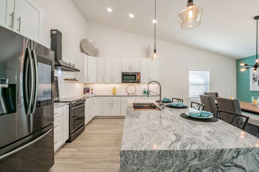 Kitchen with pendant lights and dining area — Custom home addition, pool, and renovation, Bradenton