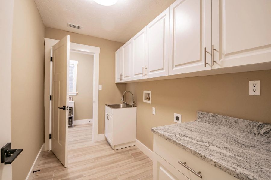 Laundry room with utility sink and cabinets — Custom home addition, pool, and renovation, Bradenton