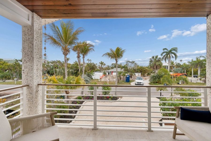 Exterior upper balcony wood ceiling cable railing tropical neighborhood view — New home construction, Longboat Key