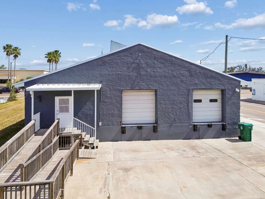 Rear exterior gray stucco double garage doors ramp — Commercial building renovation, Palmetto