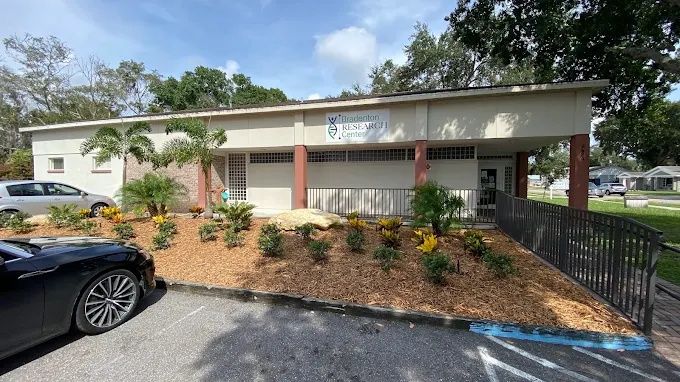 Bradenton Research Center exterior with new landscaping, palms and a black metal fence