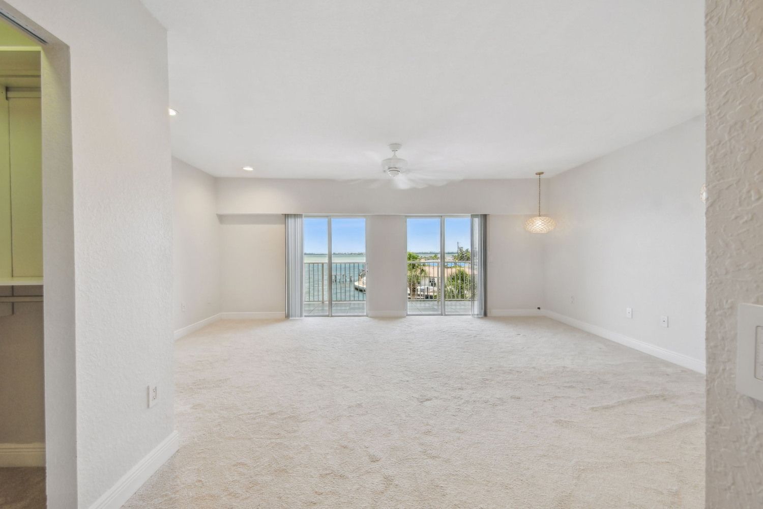 Bright living space with sliding glass doors and water views — Waterfront condo renovation, Bradenton, FL