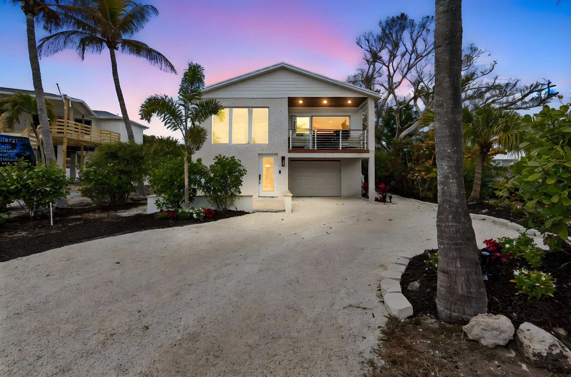 Coastal home exterior dusk two story white stucco palm trees sunset sky — New home construction, Longboat Key