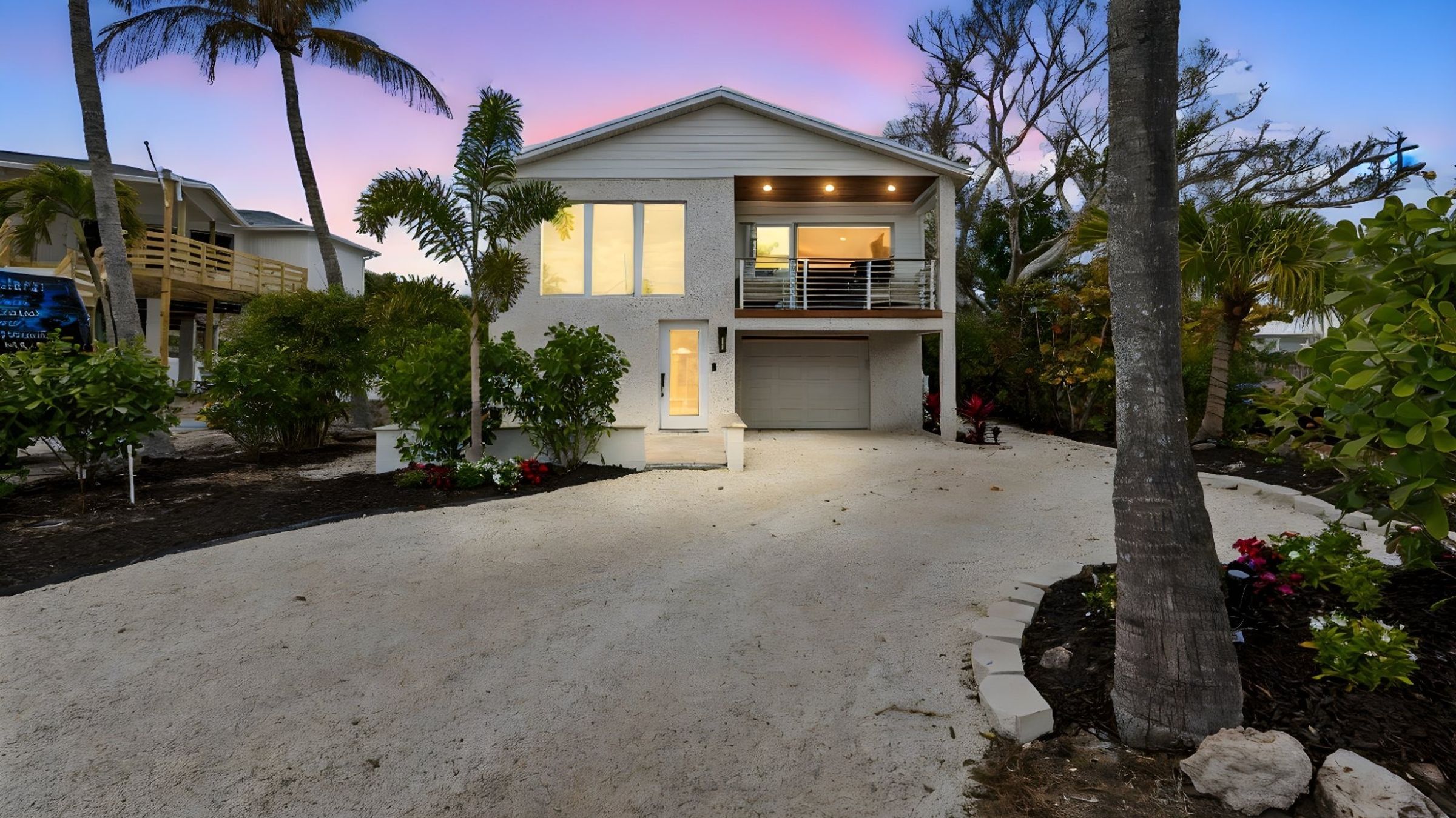 Coastal home exterior dusk two story white stucco palm trees sunset sky — New home construction, Longboat Key