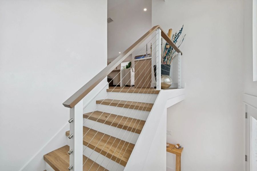 Interior staircase upper landing wood treads cable railing — New home construction, Longboat Key