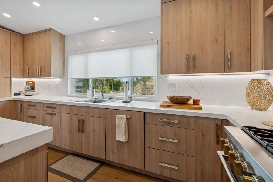 Interior kitchen sink wall wood cabinets quartz backsplash under cabinet lighting — New home construction, Longboat Key