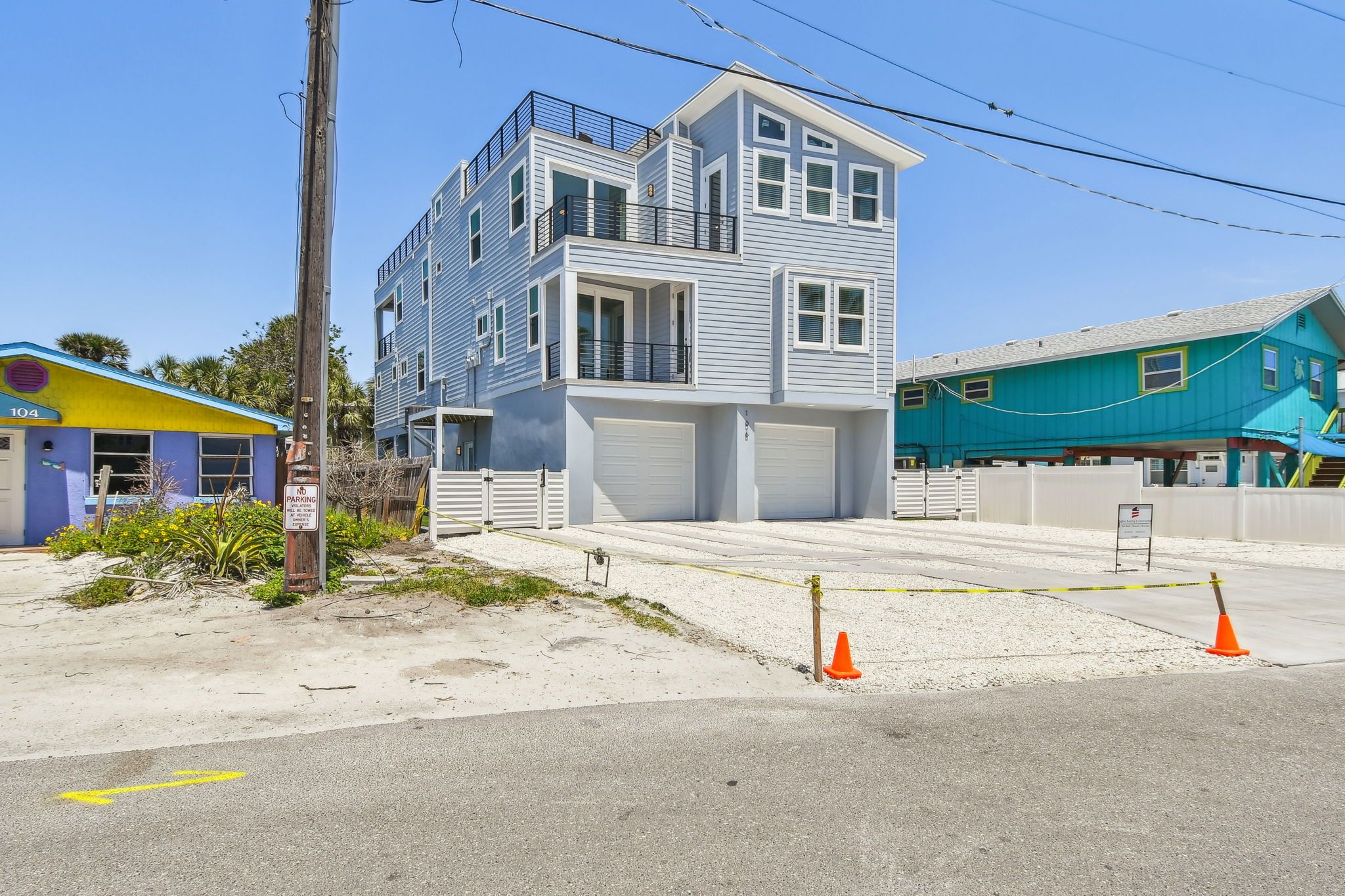 Street view of the finished three-story home between neighboring beach cottages — Coastal custom home, Bradenton Beach