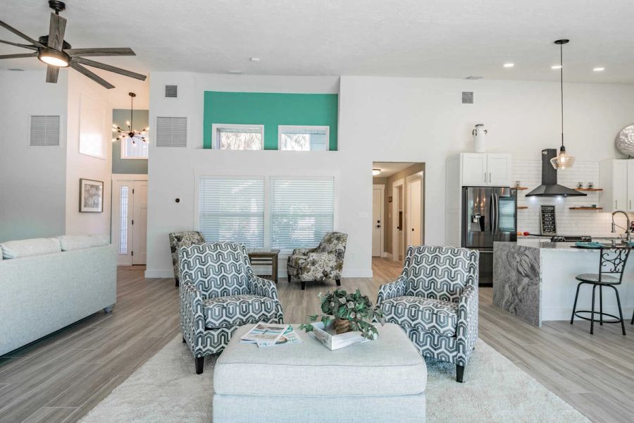 Living room with accent chairs and kitchen view — Custom home addition, pool, and renovation, Bradenton