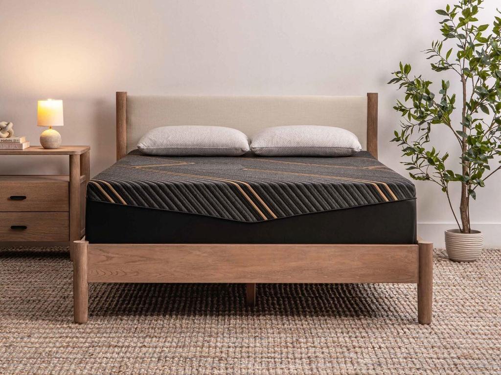 Alpine II mattress on a wood bed frame in a styled bedroom
