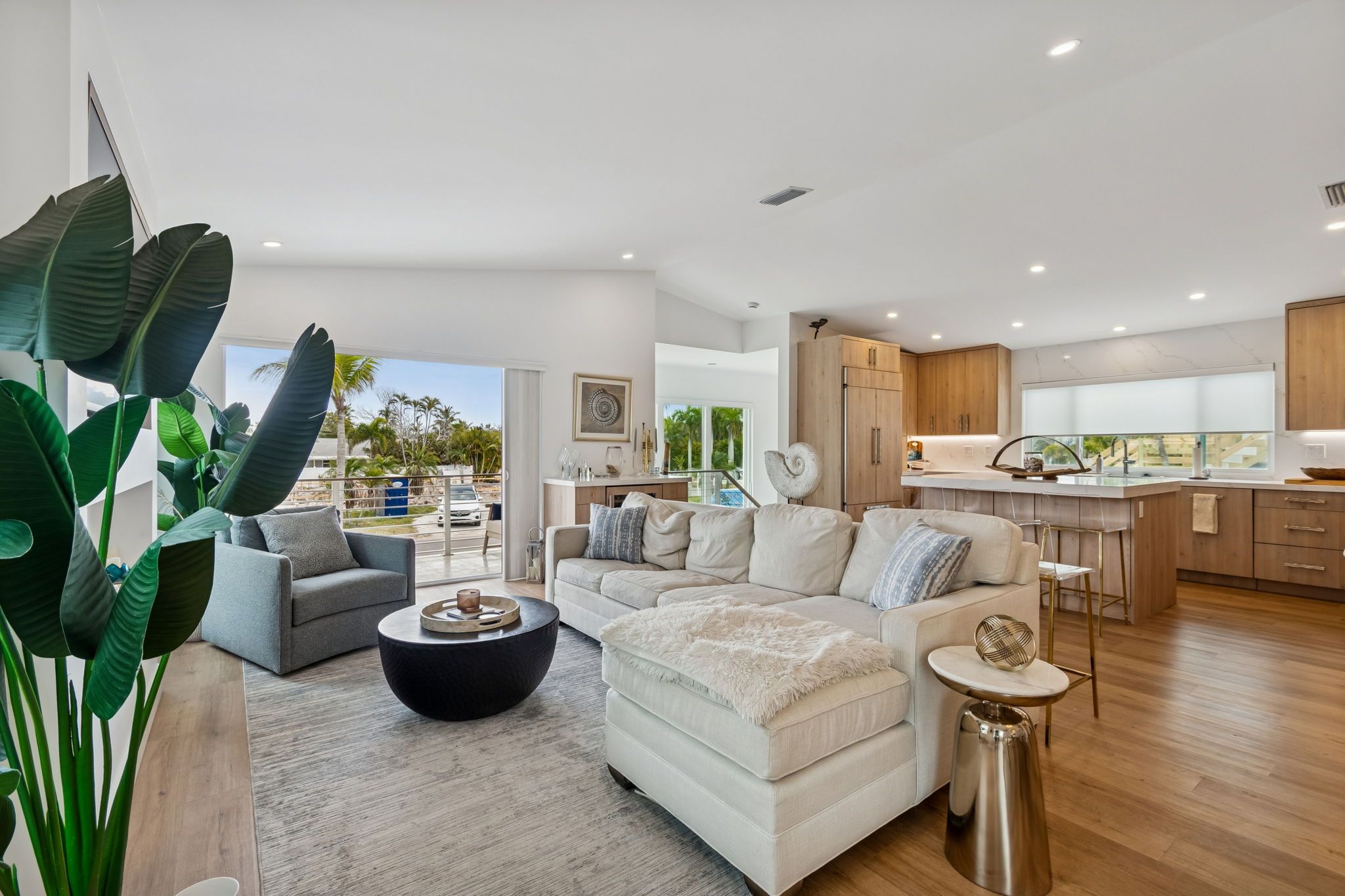 Living room with a white sectional and garden views — New home construction, Longboat Key