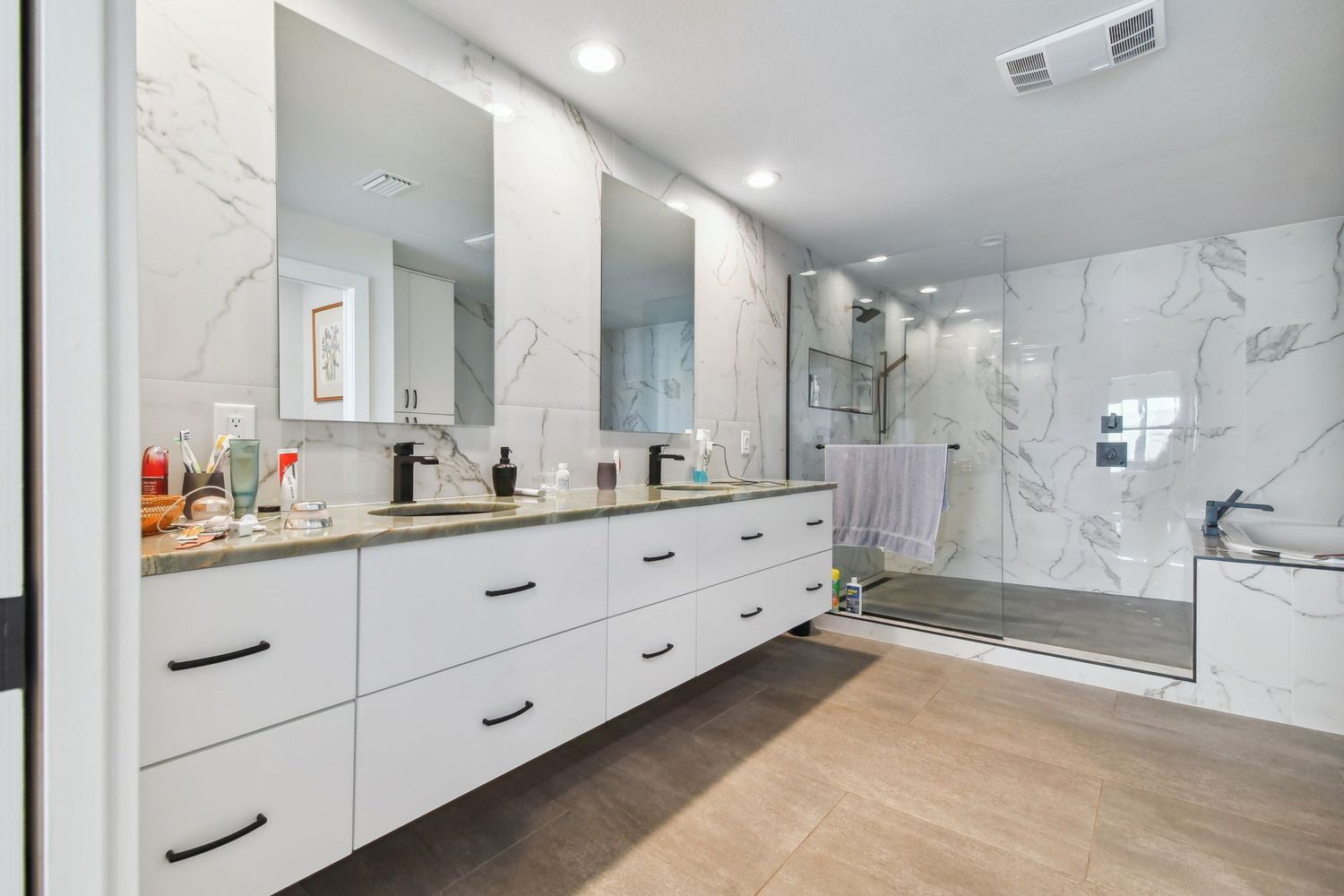 Luxury double vanity bathroom with marble walls and walk — Waterfront home renovation, Bradenton, FL