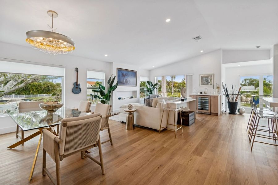 Interior open concept living dining room chandelier wood floors coastal views — New home construction, Longboat Key
