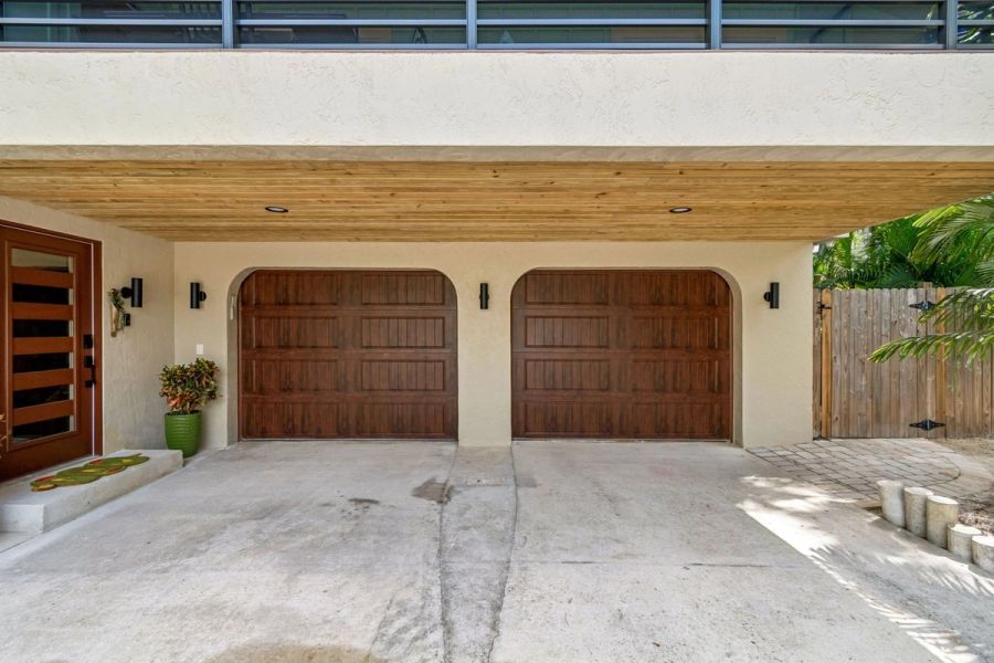 Exterior double wood garage doors arched stucco entry — Custom home addition, Longboat Key