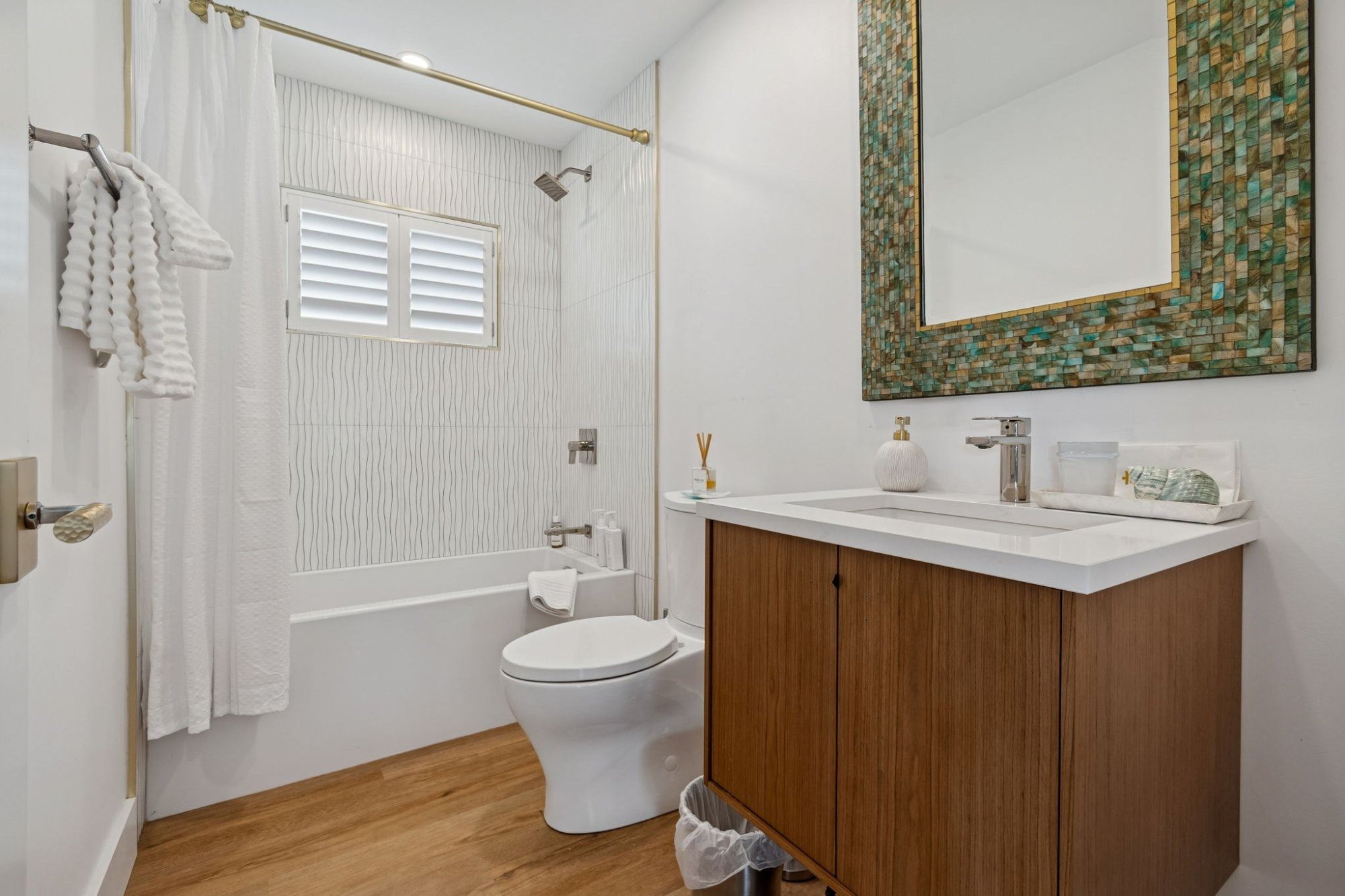Interior guest bathroom tub shower mosaic mirror frame wood vanity — New home construction, Longboat Key