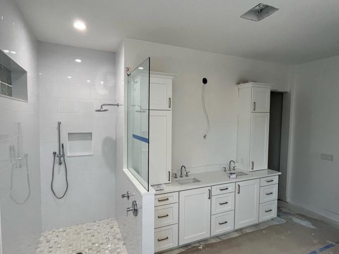 Custom white bathroom with dual vanity and glass shower under construction in Bayshore Gardens, FL