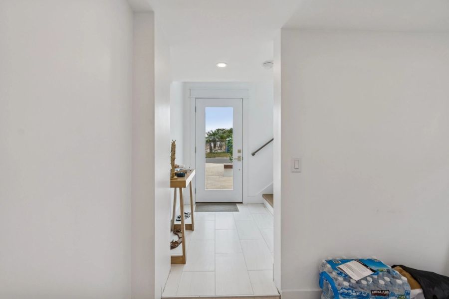 Interior ground floor entry white door glass panel — New home construction, Longboat Key