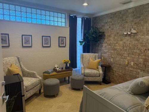 Patient lounge with armchairs, brick accent wall and glass-block windows, Bradenton Research Center