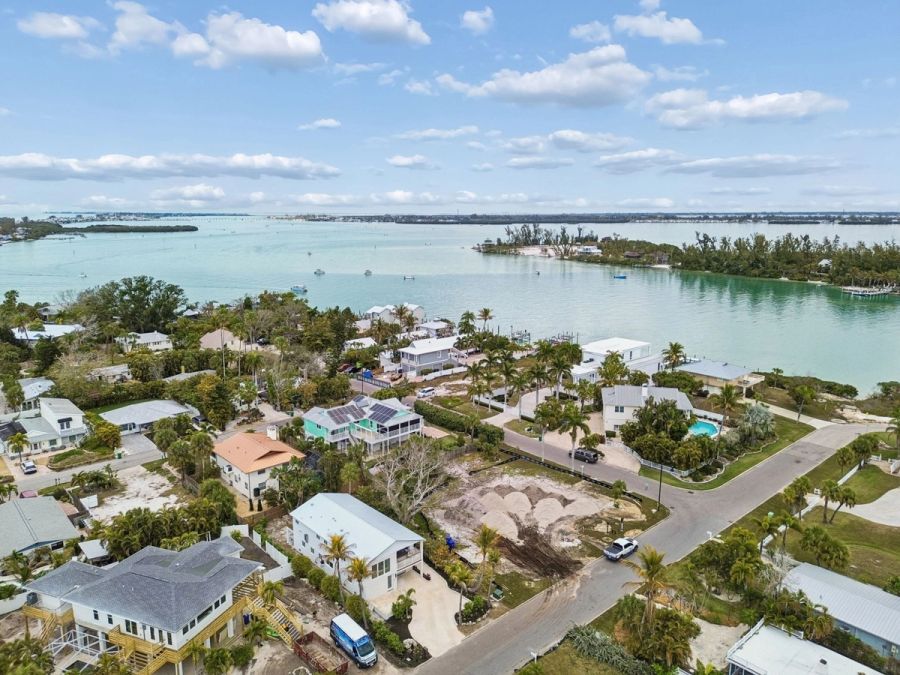 Aerial drone view coastal neighborhood waterway turquoise water palm trees — New home construction, Longboat Key