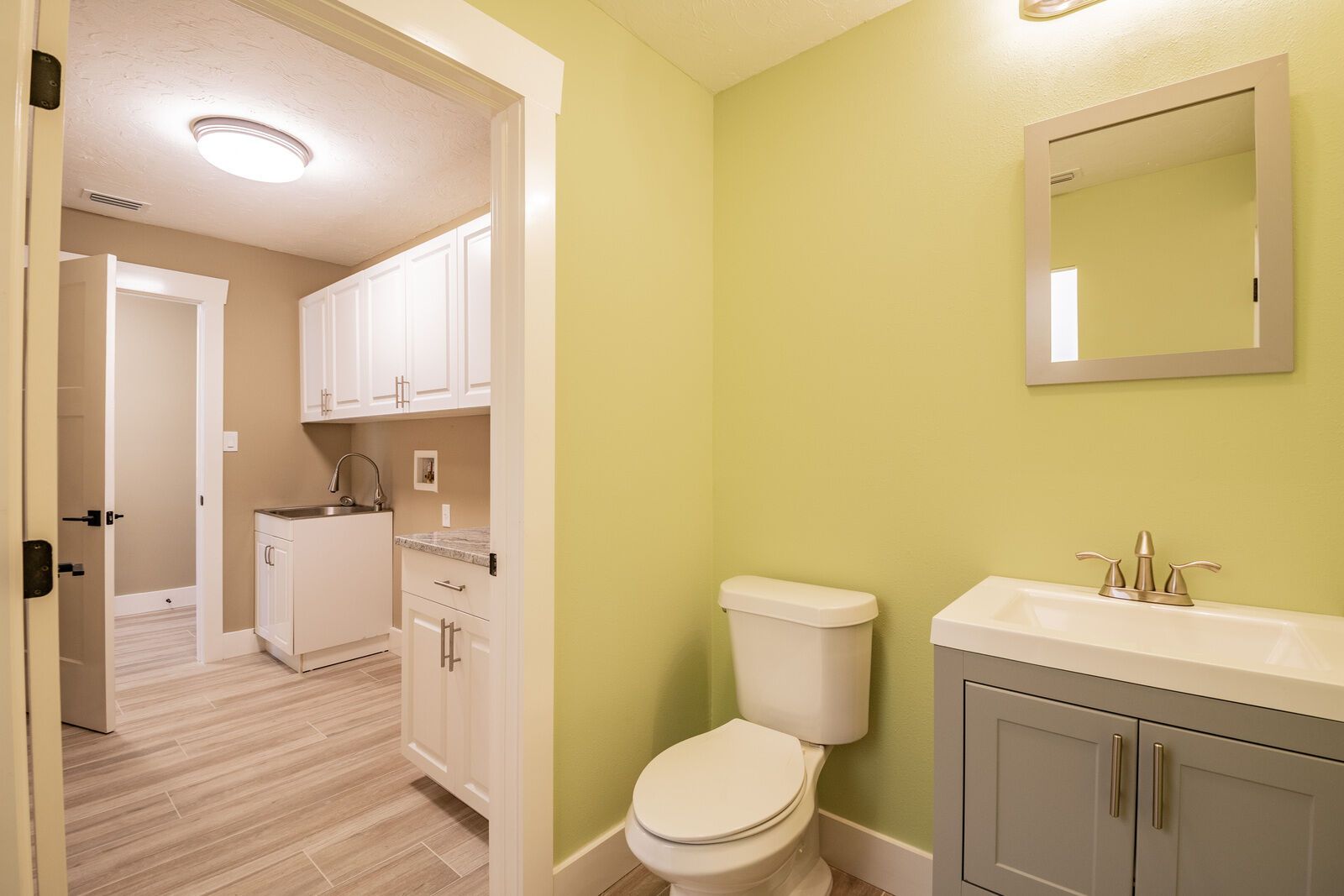 Bathroom with toilet and laundry room view — Custom home addition, pool, and renovation, Bradenton