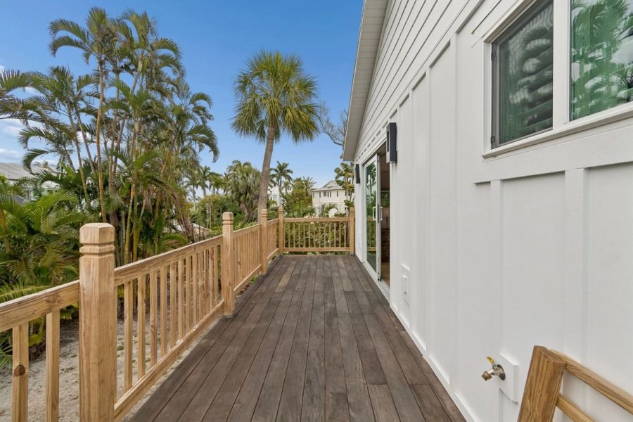 Exterior side deck wood railing tropical palm trees — New home construction, Longboat Key