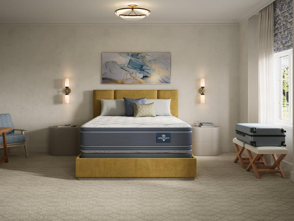 Two-sided pillow top mattress made up with bedding in a bedroom