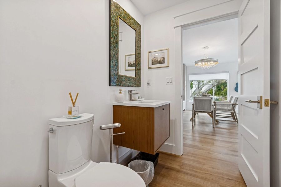 Interior guest bath floating vanity mosaic mirror view to dining room — New home construction, Longboat Key