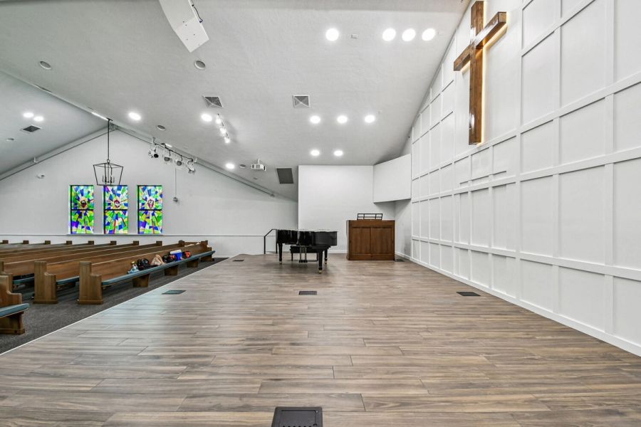 Sanctuary side angle showing stained glass windows and elevated stage — Roser Memorial Community Church, Anna Maria, FL