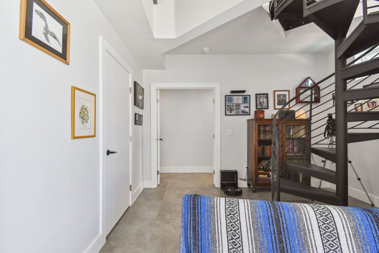 Custom hallway design with spiral staircase and personal gallery wall — Waterfront home renovation, Bradenton, FL