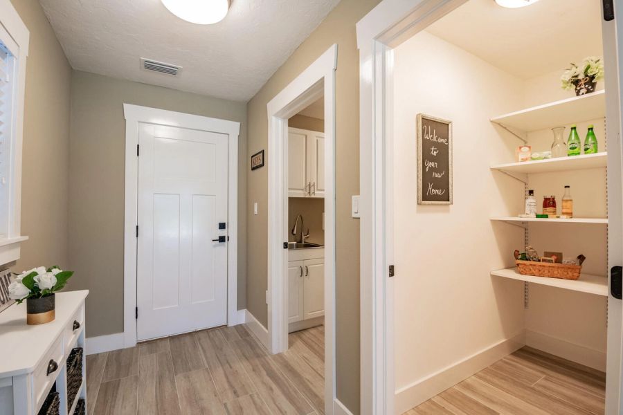 Entryway hall with pantry and welcome sign — Custom home addition, pool, and renovation, Bradenton