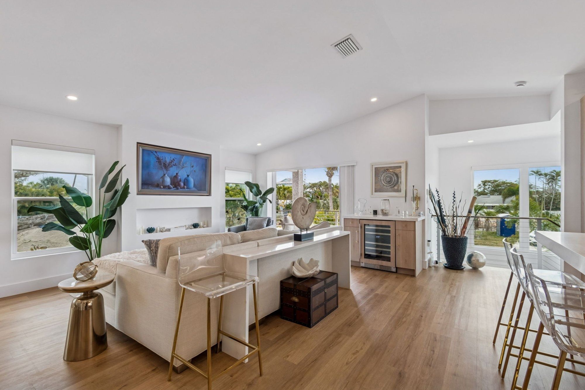 Interior living room sectional sofa wine fridge bar coastal tropical views — New home construction, Longboat Key