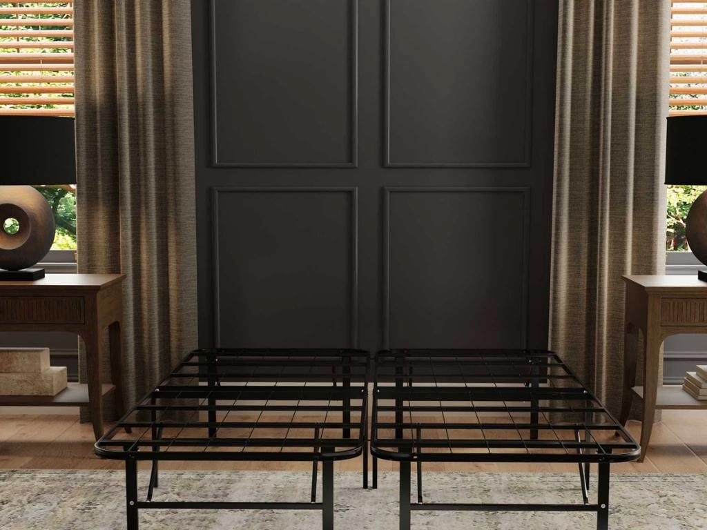 Black metal platform foundation between two nightstands in a bedroom
