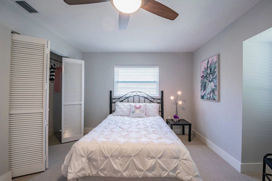 Bedroom white bedding and open closet — Custom home addition, pool, and renovation, Bradenton
