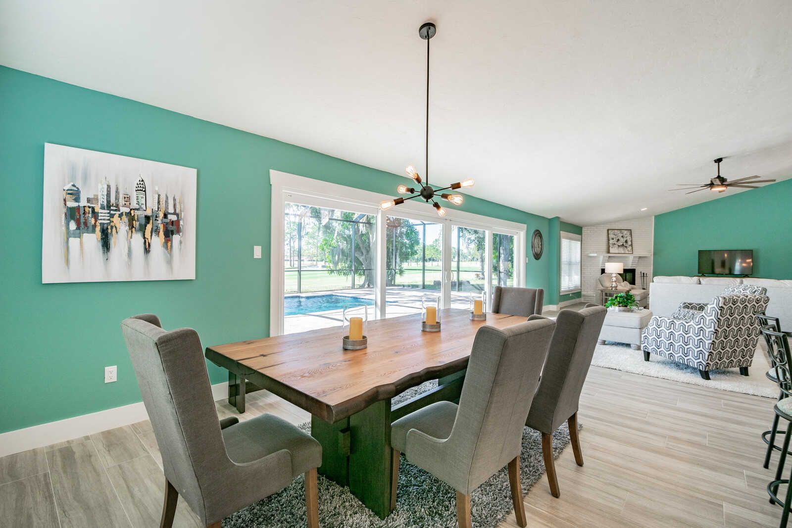 Dining room with teal wall and city art — Custom home addition, pool, and renovation, Bradenton