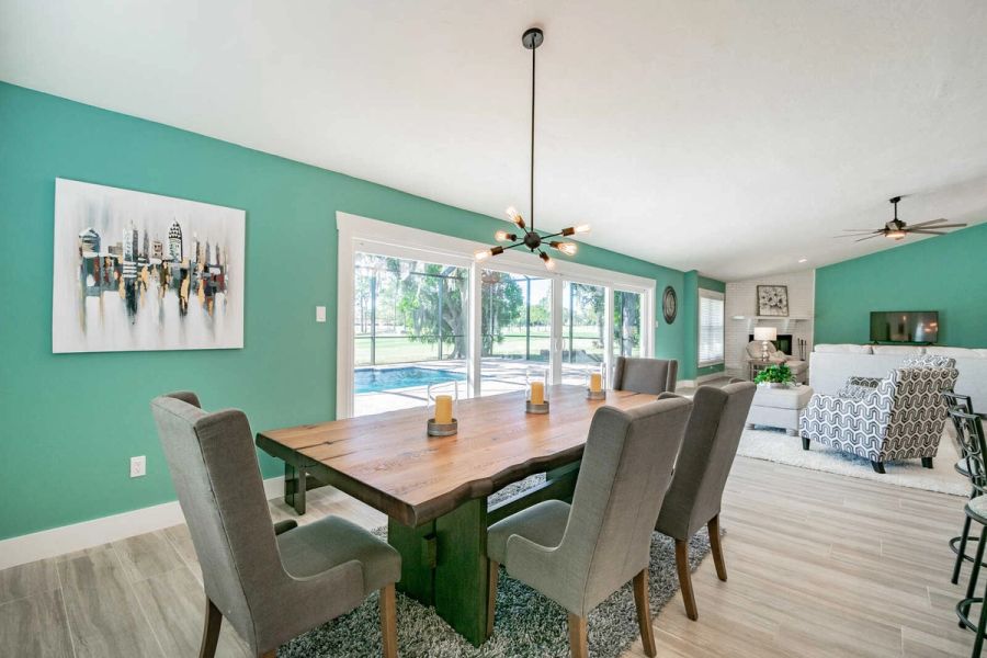Dining room with teal wall and city art — Custom home addition, pool, and renovation, Bradenton