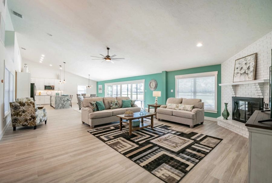 Living room wide view with kitchen and fireplace — Custom home addition, pool, and renovation, Bradenton