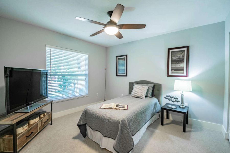 Guest bedroom with twin bed and tv — Custom home addition, pool, and renovation, Bradenton