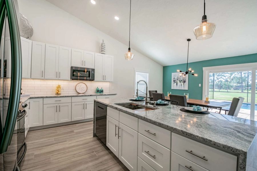 Kitchen island with teal accent wall dining area — Custom home addition, pool, and renovation, Bradenton