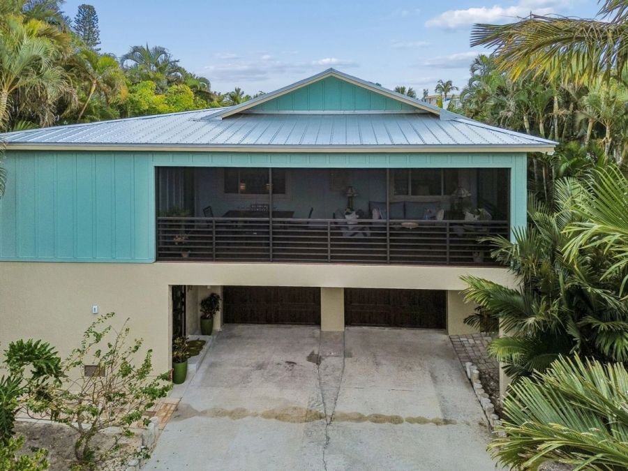 Exterior front facade teal board batten metal roof double garage — Custom home addition, Longboat Key