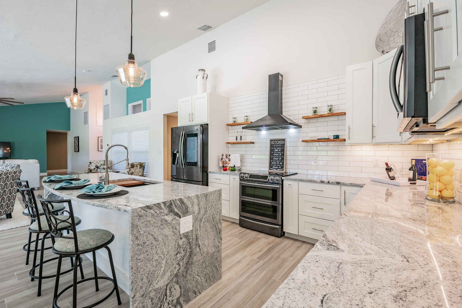 Kitchen with granite island and bar stools — Custom home addition, pool, and renovation, Bradenton
