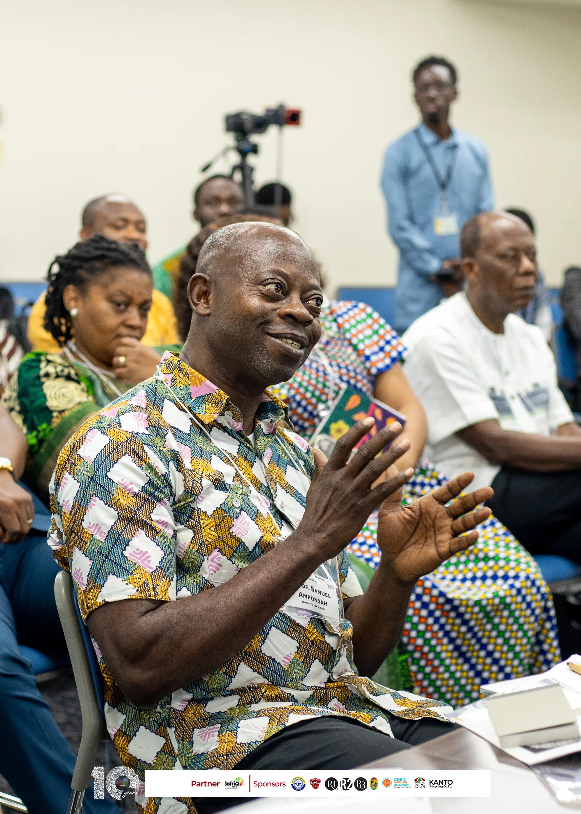 Smiling guest in a print shirt applauds from the audience