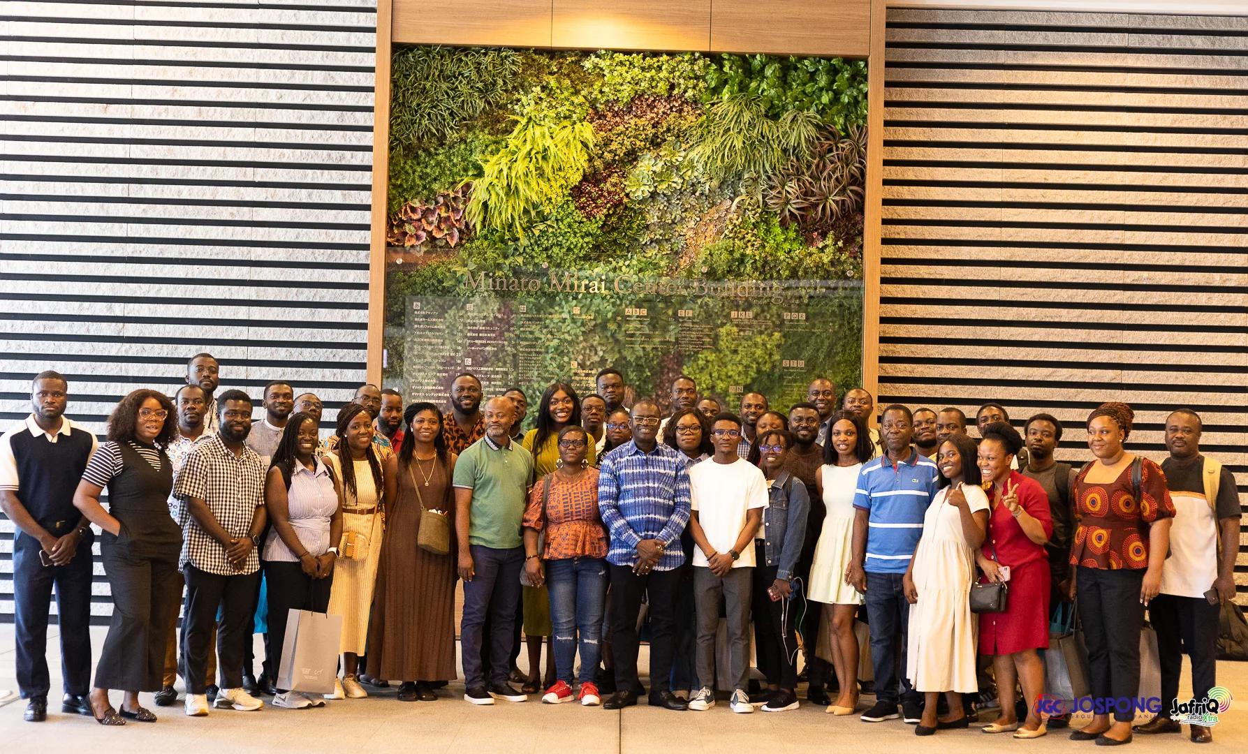 Large group of Ghanaian students and Jospong guests before a green wall