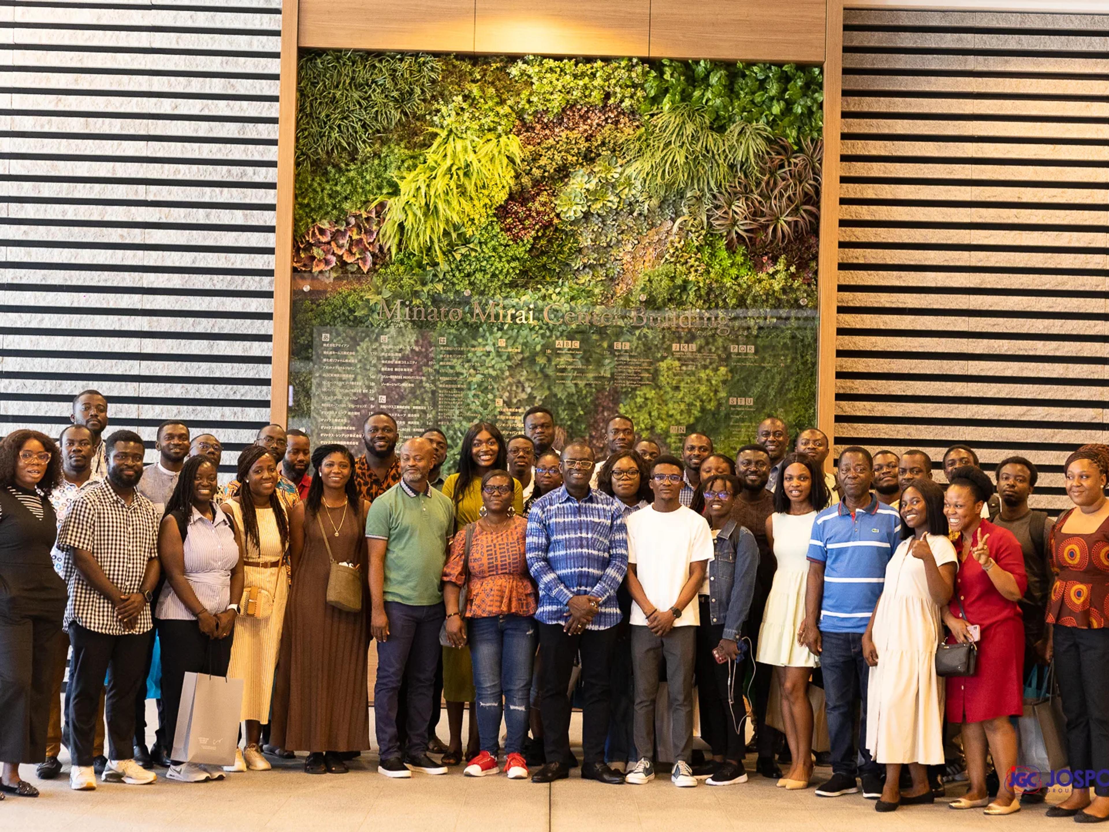Large group of Ghanaian students and Jospong guests before a green wall