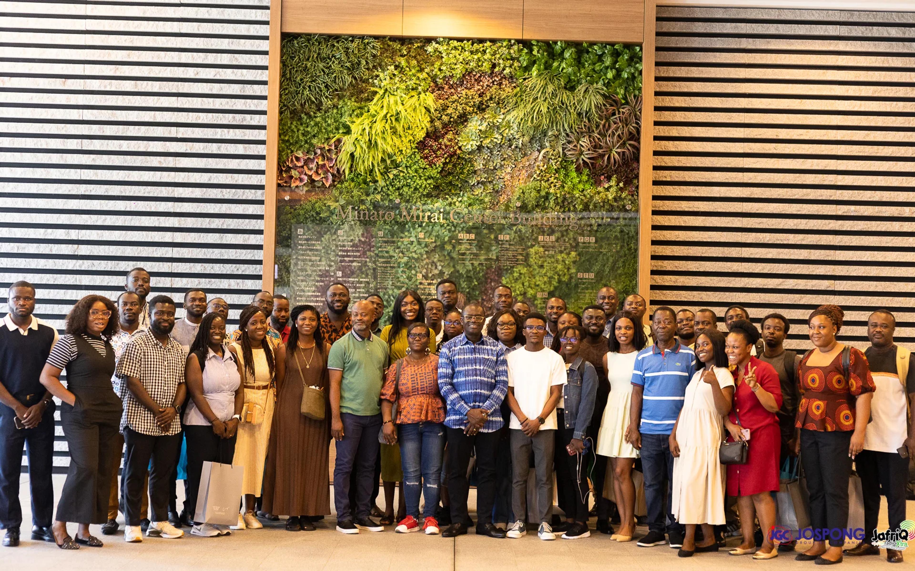 Large group of Ghanaian students and Jospong guests before a green wall