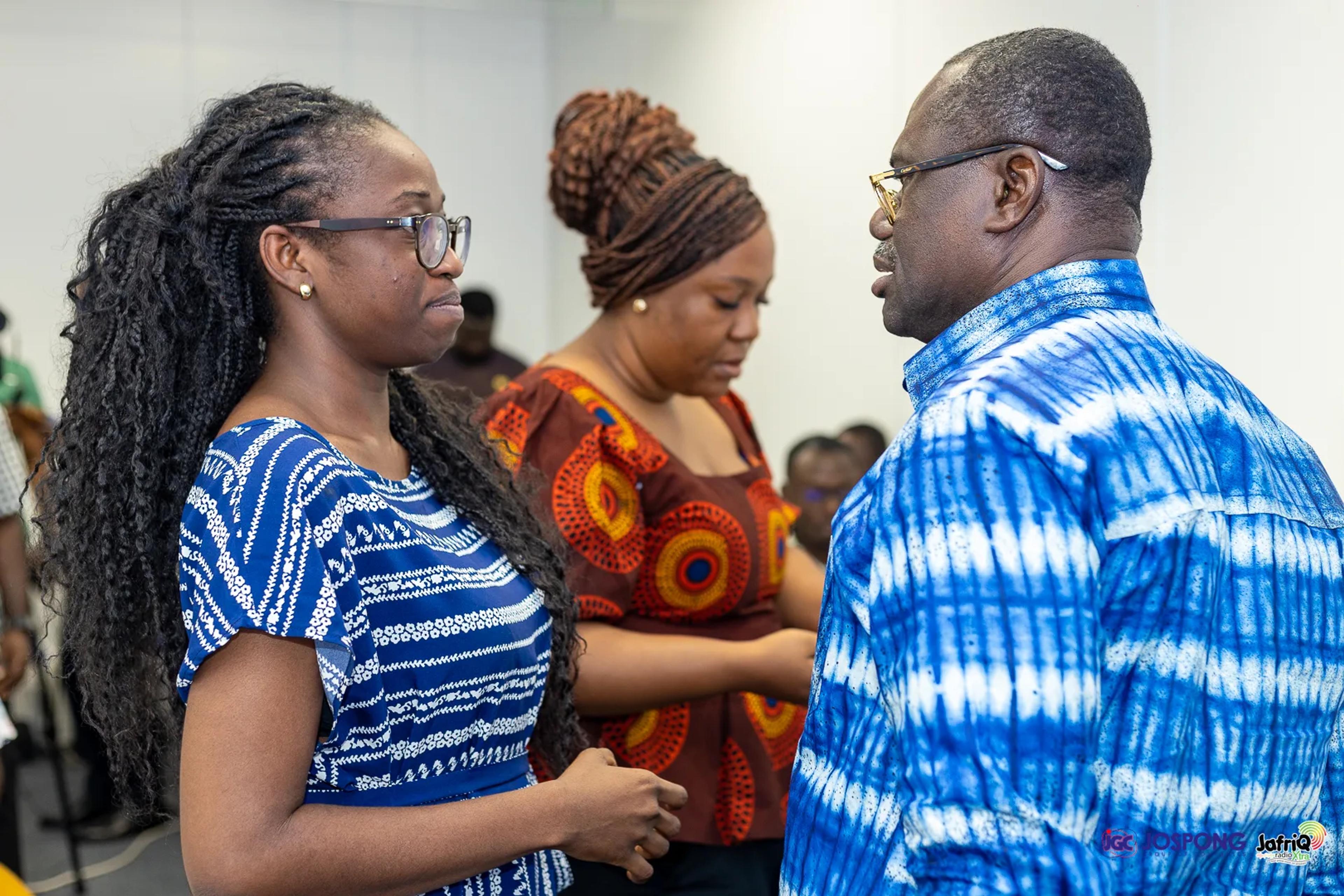 Guest in blue and white shirt talks with two students