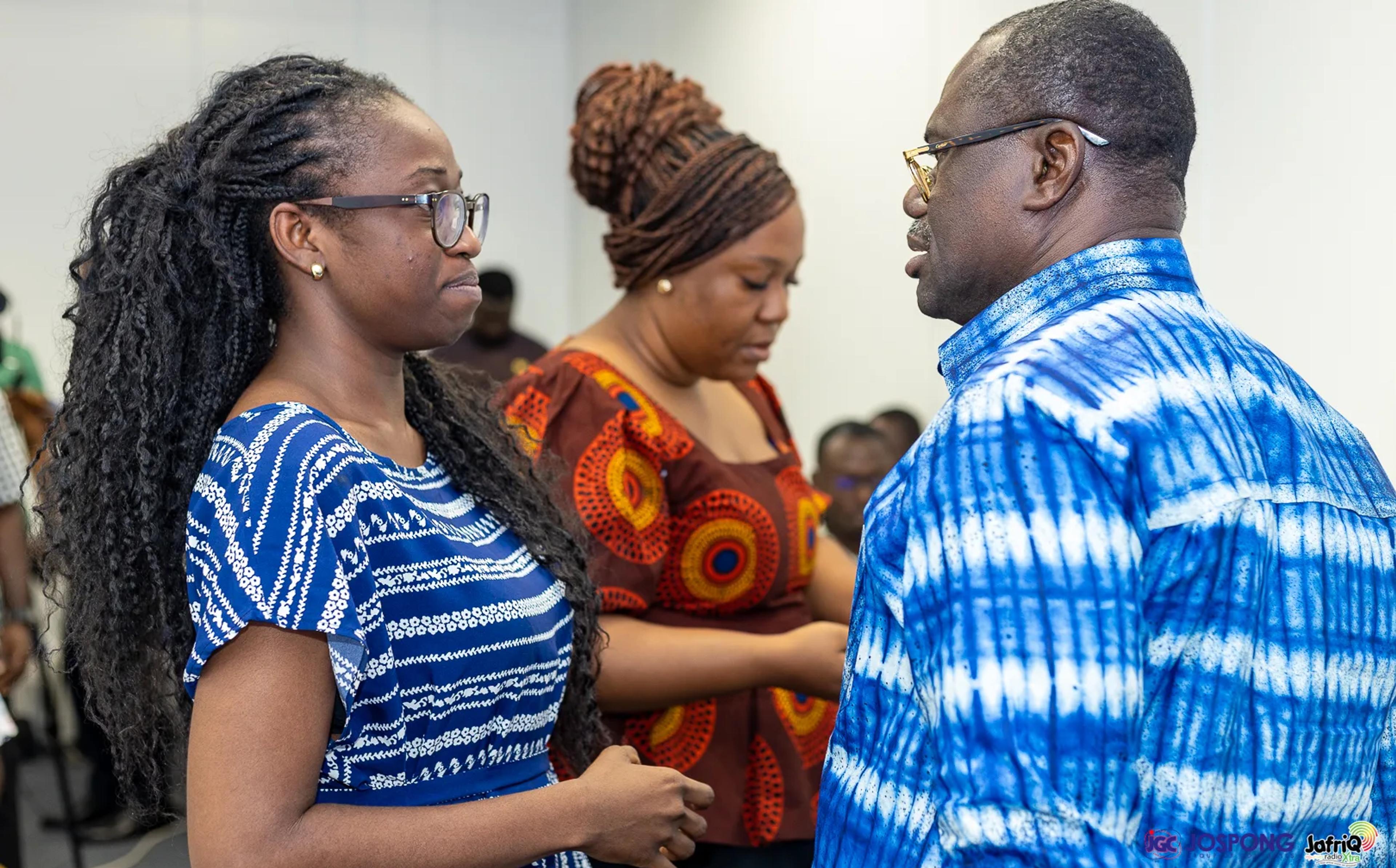 Guest in blue and white shirt talks with two students